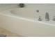 Close-up of a white tiled tub with chrome fixtures and a decorative accent pot, adding a touch of elegance at 5400 Twin Lakes Dr, South Fulton, GA 30349