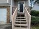 Inviting entrance with stairs leading to a front door and covered porch at 5400 Twin Lakes Dr, South Fulton, GA 30349