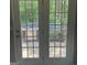 View of a backyard patio with grills and landscaping, seen through glass paneled doors at 5400 Twin Lakes Dr, South Fulton, GA 30349