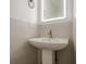 Modern powder room features a stylish pedestal sink and backlit mirror at 4959 Abbotts Glen Nw Trl, Acworth, GA 30101