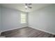 Light-filled bedroom featuring a ceiling fan, neutral paint, and stylish wood-look flooring at 4959 Abbotts Glen Nw Trl, Acworth, GA 30101