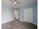 Bedroom with blue walls, wood-look floors, a ceiling fan, and a closet with sliding doors at 4959 Abbotts Glen Nw Trl, Acworth, GA 30101