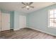 Bedroom with blue walls, wood-look floors, a ceiling fan, and a closet with sliding doors at 4959 Abbotts Glen Nw Trl, Acworth, GA 30101