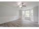 Empty room with wainscotting, crown molding, wood-look floors, windows with a view, and a ceiling fan at 4959 Abbotts Glen Nw Trl, Acworth, GA 30101