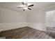 Empty room with wainscotting, crown molding, wood-look floors, and a modern ceiling fan with light at 4959 Abbotts Glen Nw Trl, Acworth, GA 30101