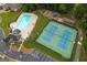 Aerial view of community pool, tennis courts, playground, and surrounding greenery at 192 Sandhurst Ct, Suwanee, GA 30024