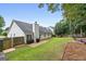 White home showcasing a large backyard with green grass, patio, and wooded perimeter for privacy at 192 Sandhurst Ct, Suwanee, GA 30024