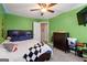 Vibrant bedroom boasts bold green walls, ceiling fan and tv at 192 Sandhurst Ct, Suwanee, GA 30024