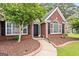 Close up front exterior, showcasing a manicured landscape leading to the entryway and covered front porch at 192 Sandhurst Ct, Suwanee, GA 30024