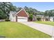 Red brick home with a well-manicured lawn and ample driveway space leading to the attached garage at 192 Sandhurst Ct, Suwanee, GA 30024