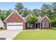 Charming brick home featuring manicured lawn, mature landscaping, and a two-car garage at 192 Sandhurst Ct, Suwanee, GA 30024