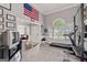 Home gym featuring exercise equipment, neutral carpet, natural light, and patriotic decor at 192 Sandhurst Ct, Suwanee, GA 30024