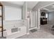 Bright bathroom features a tiled tub and shower with glass door at 192 Sandhurst Ct, Suwanee, GA 30024