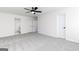 Bright bedroom features neutral carpet, a ceiling fan, two doors, and an entryway to another room at 3373 Arabian Farm Dr, Dacula, GA 30019