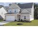 Attractive two-story home with grey siding, brick accents, and a neatly landscaped front yard at 3373 Arabian Farm Dr, Dacula, GA 30019