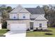 Charming two-story home featuring a brick facade, grey siding and a well-manicured lawn at 3373 Arabian Farm Dr, Dacula, GA 30019