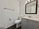 Well-lit bathroom featuring a modern vanity with gray cabinets and a dark framed mirror at 10173 Brass Ring Rd, Jonesboro, GA 30238