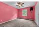 Bedroom features bright pink walls, ceiling fan, and a window offering natural light at 2000 Stacia Dr, Covington, GA 30016