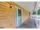 Spacious porch with wood planks and outdoor lighting fixtures on a home's facade at 2000 Stacia Dr, Covington, GA 30016
