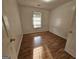 Empty bedroom with window letting in natural light and hardwood floors at 10 Nicole Ct, Covington, GA 30016