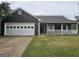 Charming home featuring a two-car garage, covered porch, and well-maintained front yard at 10 Nicole Ct, Covington, GA 30016