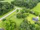 Aerial view of home and neighborhood showcases mature trees, landscaping, and fencing at 615 Coan Dr, Locust Grove, GA 30248