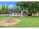 Large backyard with a fire pit area and mature trees at 615 Coan Dr, Locust Grove, GA 30248