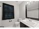 Bright bathroom with a large mirror, white toilet, and dark window treatment at 615 Coan Dr, Locust Grove, GA 30248