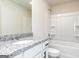 Bathroom featuring white cabinets, granite counters, and a tub with white shower surround at 493 Prescott Way, Villa Rica, GA 30180