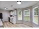 Eat-in kitchen featuring white cabinets, stainless steel appliances, and wood-look floors at 102 Natalie Ct, Dallas, GA 30157