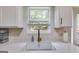 Close up of a kitchen sink with quartz counters, a modern faucet and white subway tile at 102 Natalie Ct, Dallas, GA 30157