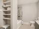 Neutral bathroom featuring decorative tiled shower-tub and ample built-in shelving for easy storage at 2739 Flagstone Se Dr, Atlanta, GA 30316