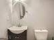 A clean bathroom with a round mirror, simple vanity, and toilet, bathed in soft, neutral tones at 2739 Flagstone Se Dr, Atlanta, GA 30316