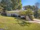 Well-maintained home with a lush front lawn, mature trees, and a charming front porch entrance at 2739 Flagstone Se Dr, Atlanta, GA 30316