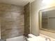 Bright bathroom featuring neutral tile backsplash and gold-trimmed mirror over vanity sink at 6300 Creekford Ln, Lithonia, GA 30058