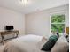 Bedroom with neutral walls, a desk, and a window view of lush greenery at 5662 Valley Loop, Fairburn, GA 30213