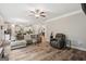 Open-concept living space with wood flooring, comfortable seating, and seamless flow into the kitchen and dining area at 5662 Valley Loop, Fairburn, GA 30213