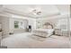 Bright main bedroom features tray ceiling, large windows and a cozy sitting area for relaxing at 5662 Valley Loop, Fairburn, GA 30213