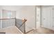 Upstairs hallway with decorative railing, leading to a bedroom with white doors, providing a clear sense of direction at 5662 Valley Loop, Fairburn, GA 30213