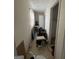 Narrow hallway featuring dated flooring, drab walls, and natural light from a window at the end of the hall at 8373 Chicago Ave, Douglasville, GA 30134