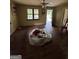 Empty living room with original hardwood floors, ceiling fan, and natural light, needs some renovation at 8373 Chicago Ave, Douglasville, GA 30134