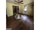 Empty living room with original hardwood floors, ceiling fan, and natural light, needs some renovation at 8373 Chicago Ave, Douglasville, GA 30134