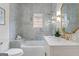 Stylish bathroom featuring marble tile, a soaking tub, a vanity with gold fixtures and a window at 995 Lena Nw St, Atlanta, GA 30314