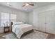Comfortable bedroom with a ceiling fan, window with blinds, plush bedding, and a large closet at 995 Lena Nw St, Atlanta, GA 30314