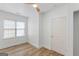 Well-lit bedroom with a window, wood flooring, and a white door, providing a clean and simple aesthetic at 995 Lena Nw St, Atlanta, GA 30314