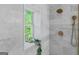 Relaxing shower with marble tiling, and a window with greenery, offering a spa-like experience at 995 Lena Nw St, Atlanta, GA 30314