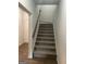 A carpeted staircase with a wood handrail and a glimpse of the front door at 3810 Equity, Powder Springs, GA 30127