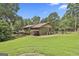 View of the backyard, showing a deck, back of house, and wooded area at 6220 Petersburg Rd, Fairburn, GA 30213