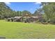 Well-manicured lawn in the backyard featuring mature trees and a charming home in the background at 6220 Petersburg Rd, Fairburn, GA 30213