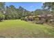 Expansive backyard featuring lush lawn, trees, and a charming fence, offering serene outdoor living at 6220 Petersburg Rd, Fairburn, GA 30213